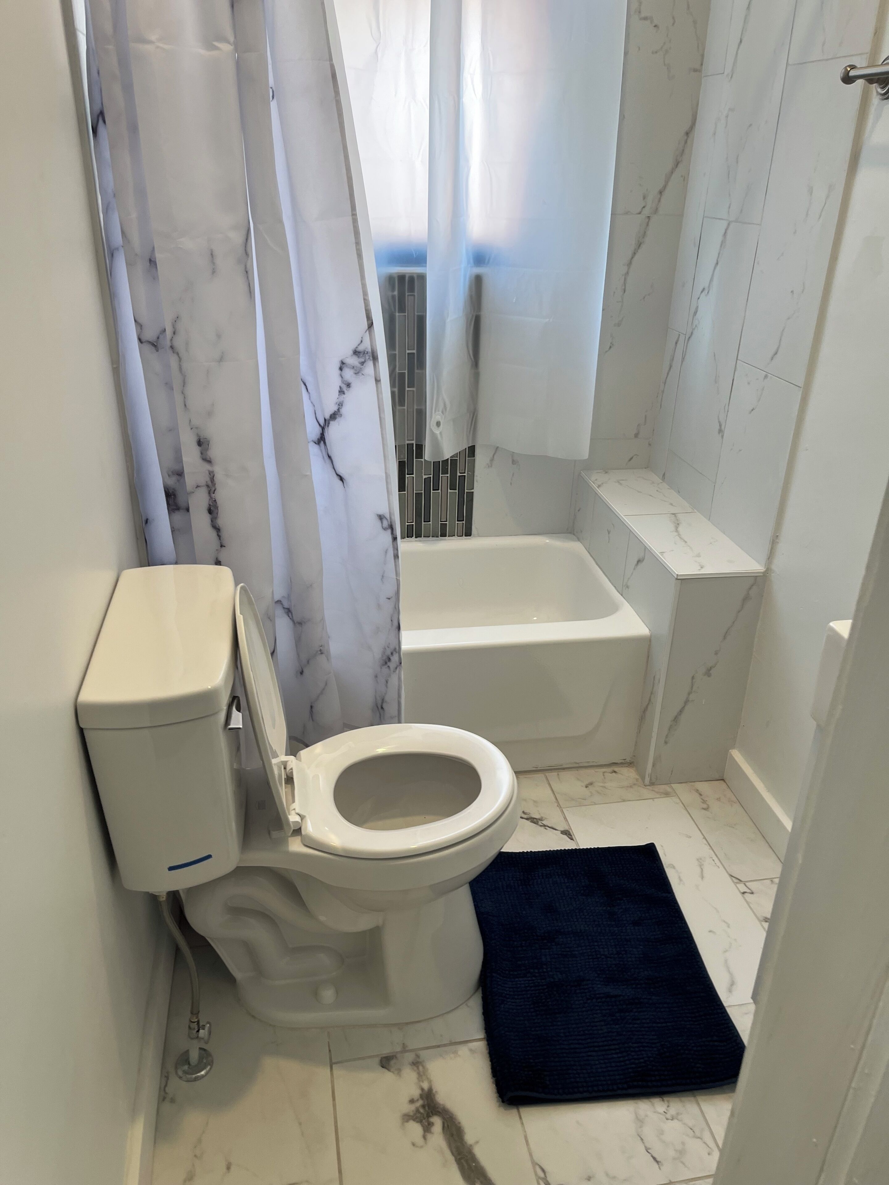 Un baño con inodoro, bañera y zona de ducha.