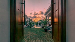 A pathway leading to a building with a sunset view. - Theodosia Villa (Kutuh)