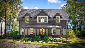 A two-story house with a gabled roof, a front porch, and a well-maintained garden. - Lakeview Landing -Lakefront, Private Dock, Wood Burning Fireplace (Morganton)