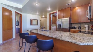 A modern kitchen with granite countertops, stainless steel appliances, and wooden cabinets.