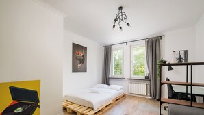 A modern bedroom with a wooden bed, a desk, and a chair. - Grójecka City Gateway Apartment (Warszawa)