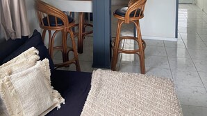 Un espace de vie compact comprenant un coin repas, une kitchenette et une vue sur l’extérieur.