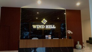 A reception desk with a marble top and a sign that reads "WIND HILL MOUNTAIN VIEW RESORT". - Wind Hill Mountain View Resort (Megamendung)