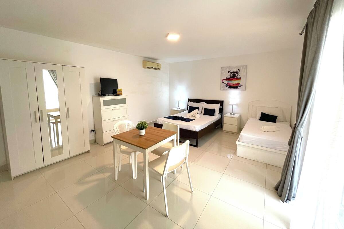 Hotelkamer met een bed, een bureau, een stoel, een kledingkast en een schilderij aan de muur.