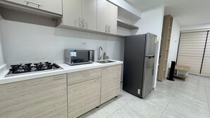 Frigorífico, microondas, cafetera o tetera y utensilios de cocina