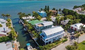 Un quartier résidentiel situé sur la côte, avec des maisons, un quai et une vue dégagée sur la mer.