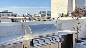 An outdoor kitchen with a built-in grill, storage drawers, and a gas supply.