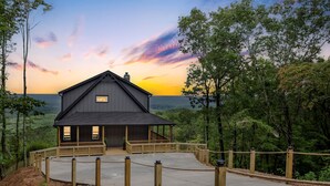 A lodge with a porch and a view of the surrounding forest. - Stunning Views | Sauna | Hot tub | Bar- 2 Kitchens (Ranger)