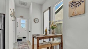 Une cuisine avec une table en bois, un banc et un vase rempli de fleurs.