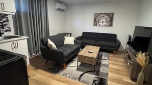 Un salon moderne avec un canapé, une table basse et un meuble pour la télévision.