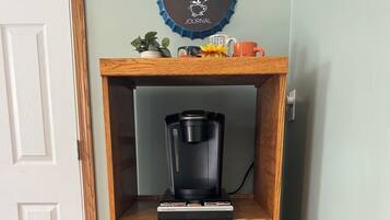 Een houten kast met een koffiezetapparaat en magnetron erboven.