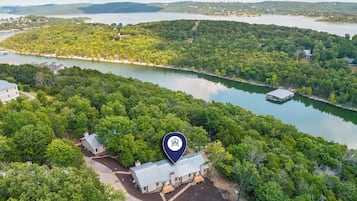 A lakeside property with a dock, a house, and surrounding forest.