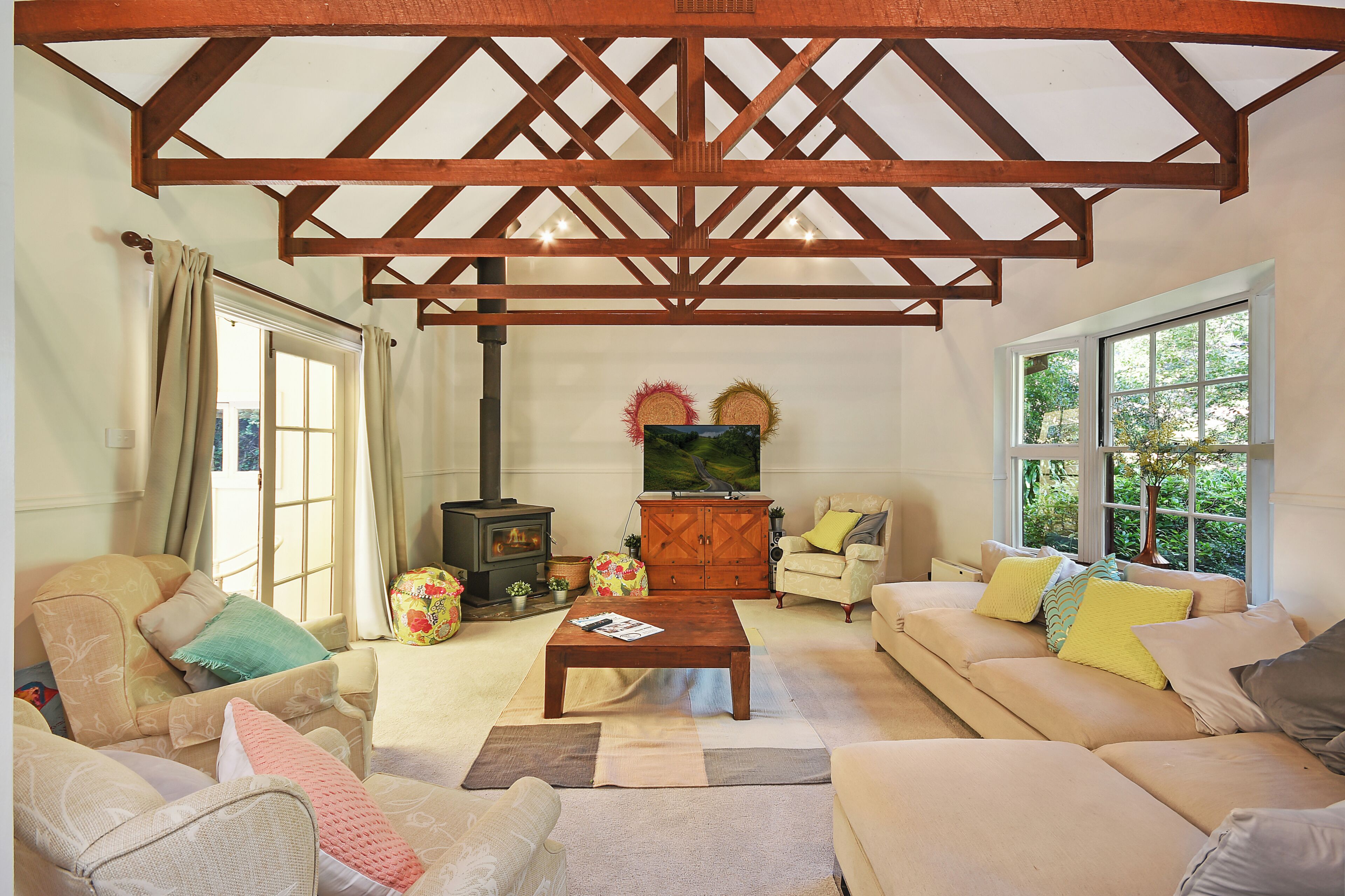 A cozy living room with a wooden ceiling, a sofa set, a coffee table, and a fireplace.