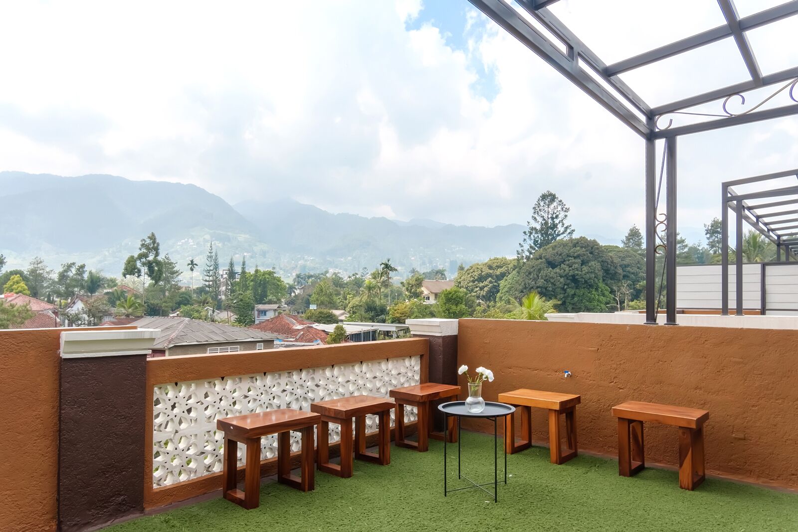 A rooftop terrace with a view of mountains and a cityscape.