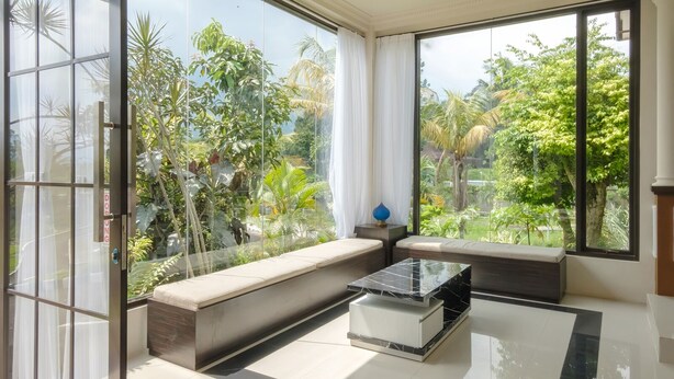 A modern room with large windows, a bench, and a marble coffee table. - Salma Syariah by TwoSpaces, Bogor (Cisarua)