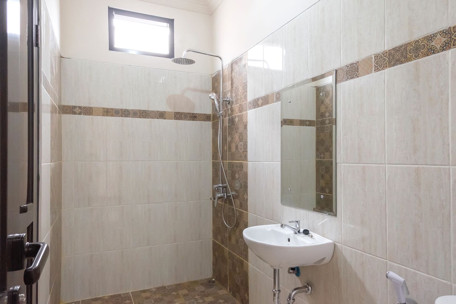 A bathroom with a shower, a sink, and a mirror.