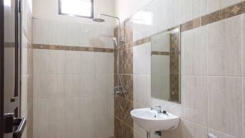A bathroom with a shower, a sink, and a mirror.