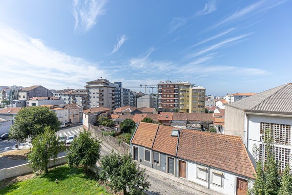 A residential area with a mix of modern and traditional buildings, featuring a variety of roof styles and a clear blue sky.