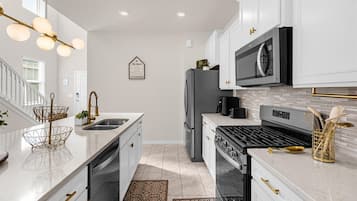 Een koelkast met diepvriezer, een microgolfoven, een oven, een kookplaat