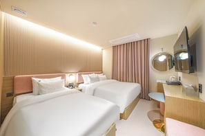 A hotel room with two beds, a desk, a mirror, and a television. - Yongin IPPDA Petit (Yongin)