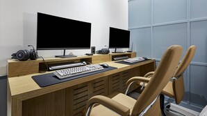 Una oficina moderna con dos monitores, un teclado, un ratón y un auricular sobre un escritorio.