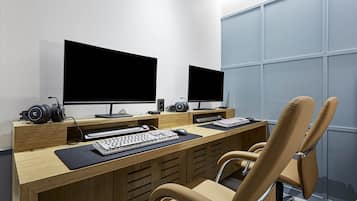 Una oficina moderna con dos monitores, un teclado, un ratón y un auricular sobre un escritorio.