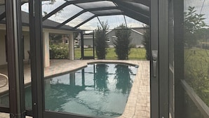 Ein Schwimmbad mit Glasveranda und einer Terrasse mit Blick auf die umliegende Landschaft.