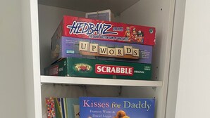 A bookshelf with various board games and a book. - Cityscape minutes walk from all the city offers (Christchurch)