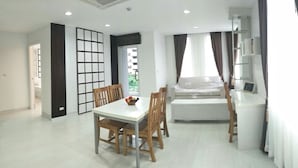 Una sala de estar moderna con comedor, un sofá y una televisión.
