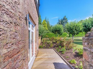 A stone building with a wooden deck leading to a glass door. - 3 bedroom accommodation in Kirkton of Lethendy (Kirkton of Lethendy)