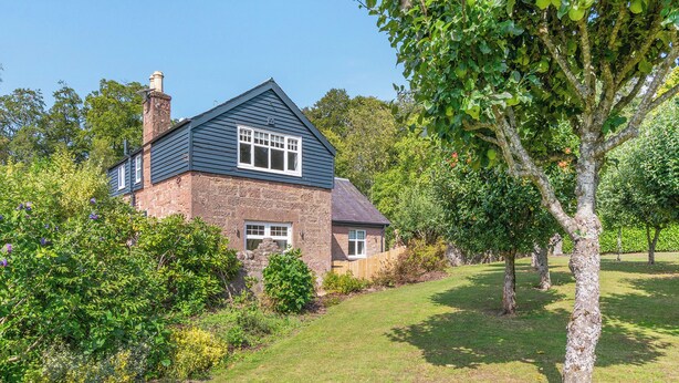 A house with a stone facade, a pitched roof, and a well-maintained lawn. - 3 bedroom accommodation in Kirkton of Lethendy (Kirkton of Lethendy)