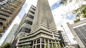 A modern high-rise building with a unique angular design, featuring multiple balconies and large windows.