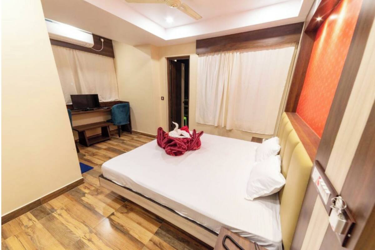Une chambre d’hôtel équipée d’un lit, d’un bureau, d’une chaise et d’un téléviseur.