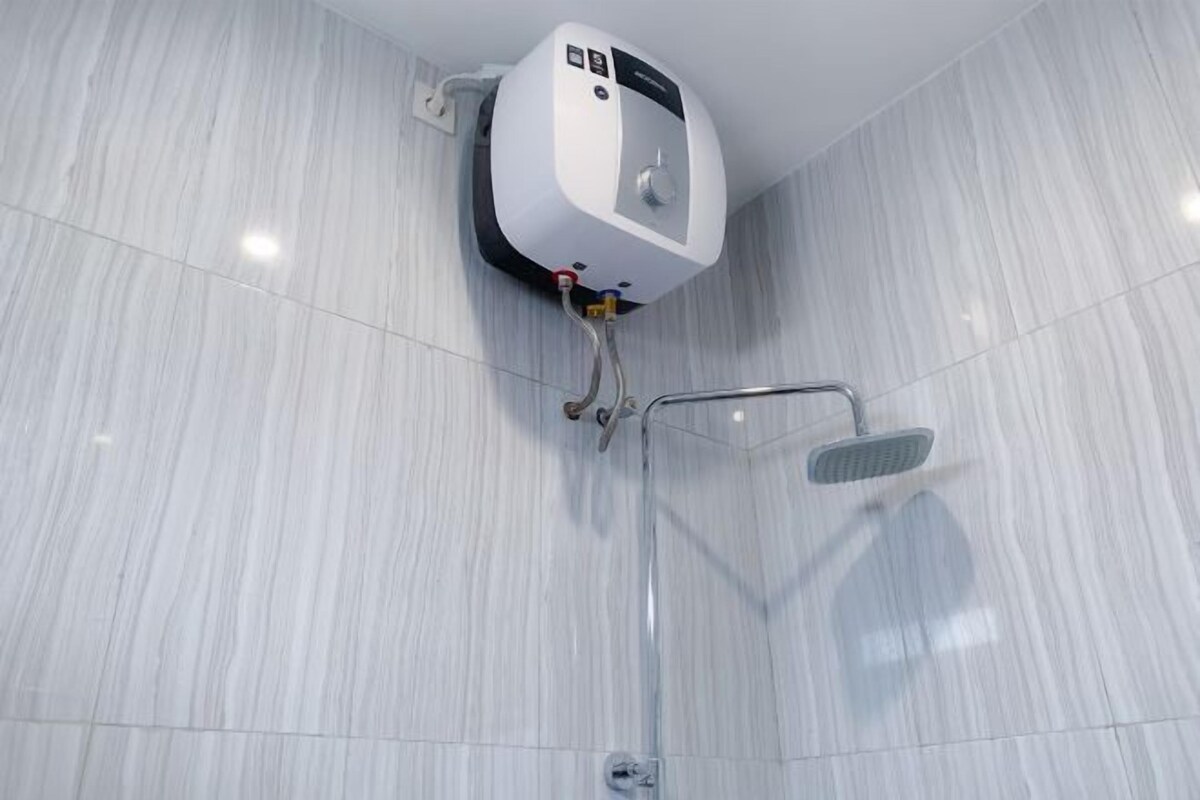 Une salle de bain moderne dotée d’une douche murale, d’un panneau de commande et d’un pommeau de douche à main.