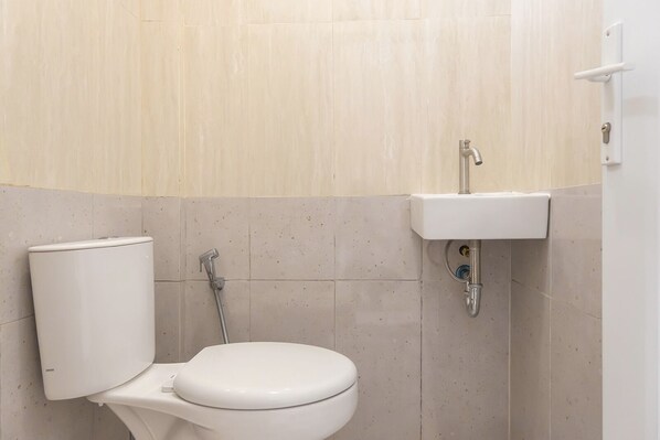 A bathroom with a toilet, a sink, and a shower.