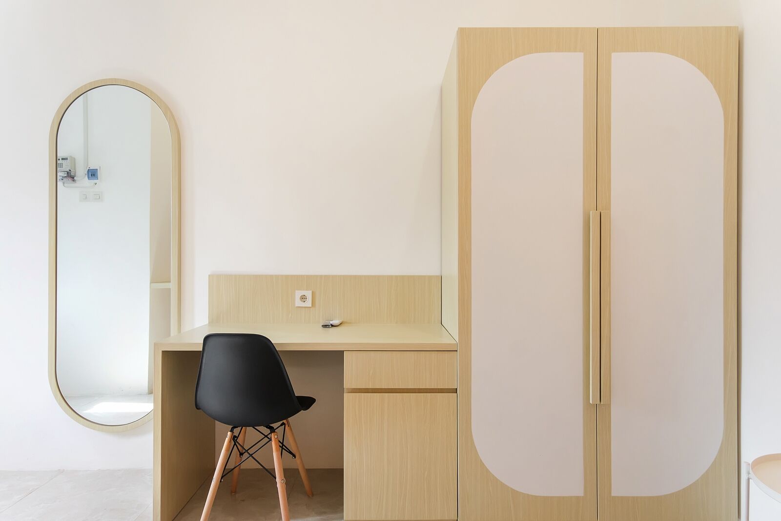 Een strak ingerichte kamer met een bureau, een stoel en een kledingkast.