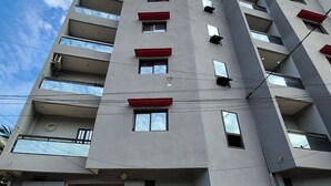 A multi-story residential building with balconies, a ground-level entrance, and a visible storefront with goods. - Hidden Gem in Ouakam [Mamelles] (Dakar)