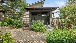 A building with a sloped roof, a covered entrance, and a sign indicating it is a rest area. - Relaxing Lake Escape | 1BR | Pickleball | BBQ (Lake Travis)