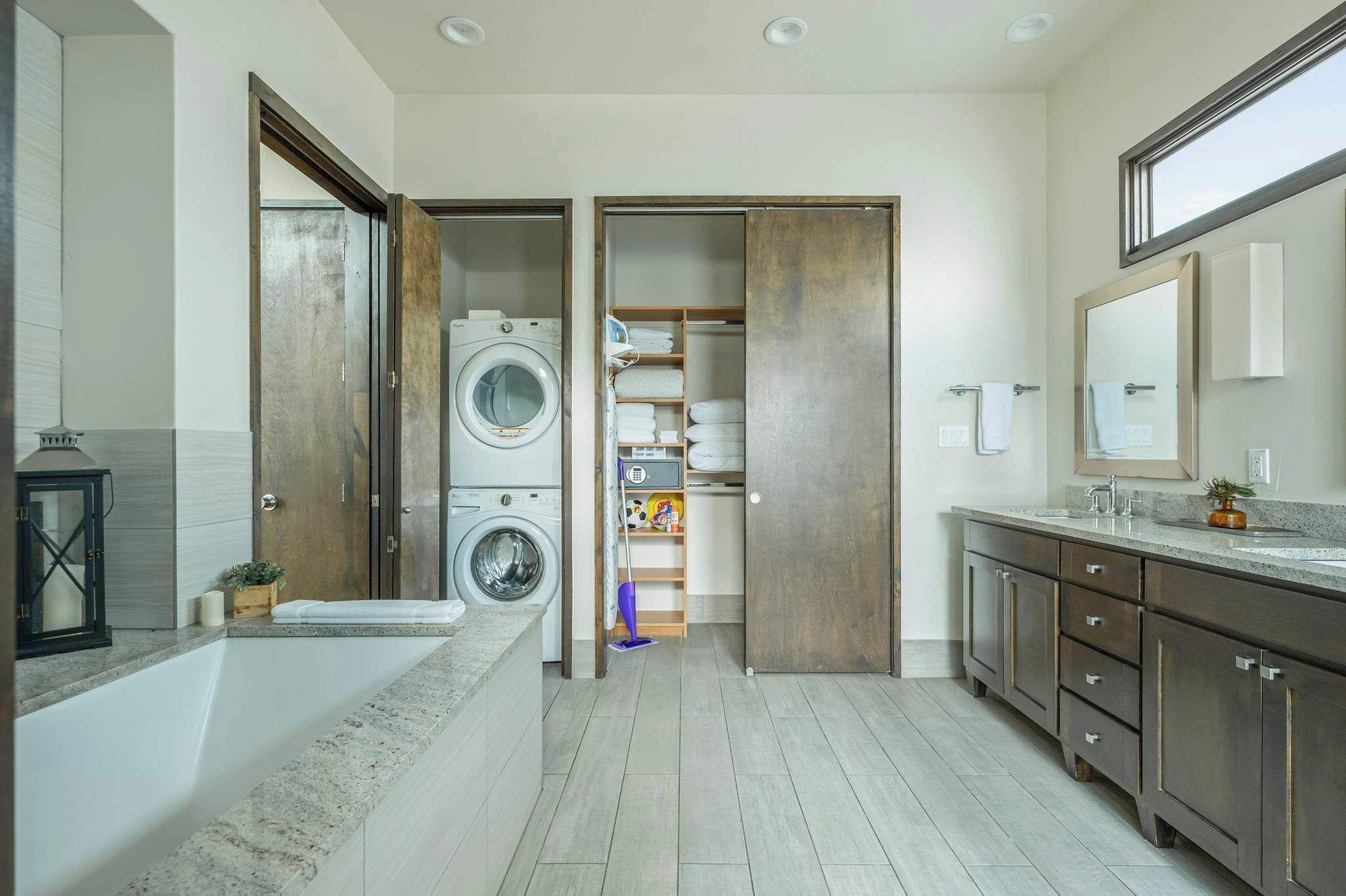 Une salle de bain moderne avec une baignoire, un lave-linge et un dressing.