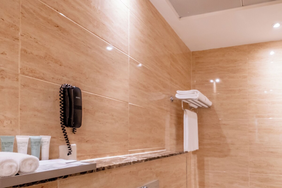 A modern bathroom with a toilet, shower, and bathtub.