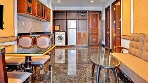 A compact living area with a dining table, sofa, and a washing machine. - Nicecy Hotel & Apartment - Central Sai Gon (Ho Chi Minh City)
