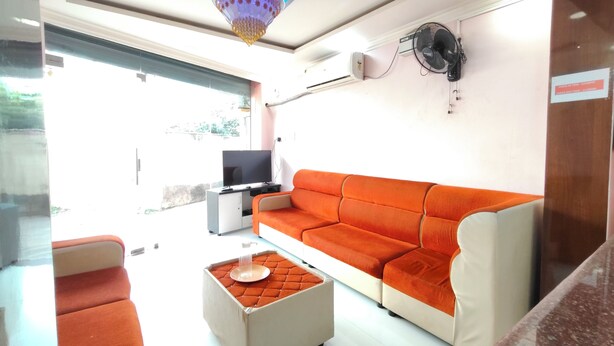 A modern living room with a sofa, a television, and a small table. - Dhanas Residency Pondicherry (Puducherry)