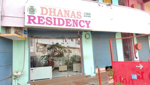 A building with a sign reading "Dhanas Residency" and a partially visible window. - Dhanas Residency Pondicherry (Puducherry)