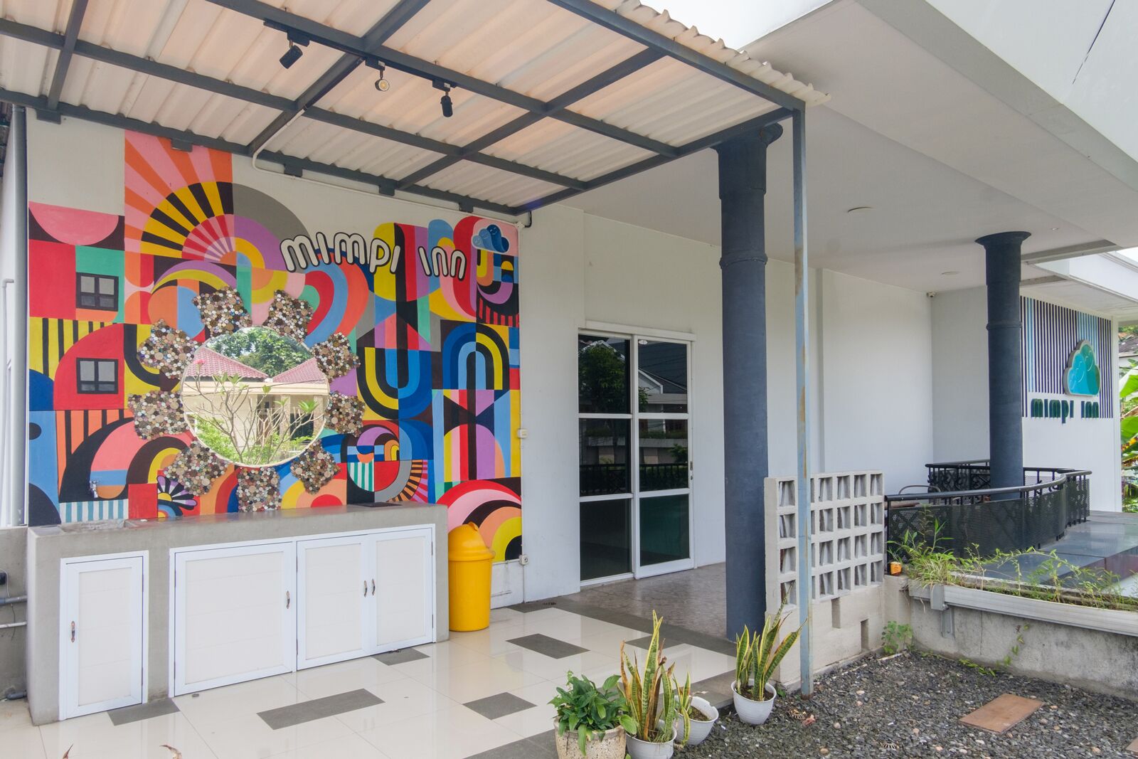 A colorful mural with geometric patterns and text on a building facade.