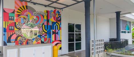 A colorful mural with geometric patterns and text on a building facade.