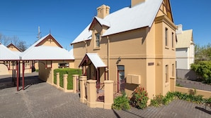 A large, two-story building with a gabled roof and a covered driveway. - Porters Cottage Grande (2 units) (Albury)