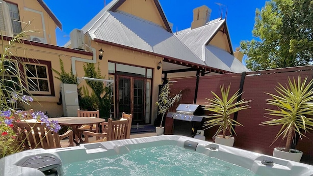 A backyard with a hot tub, outdoor furniture, and a barbecue grill. - Porters Cottage Grande (2 units) (Albury)