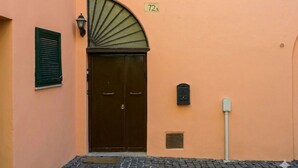 A building with a double door, a mailbox, and a small vent on the wall.