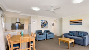 A modern living room with a dining table, two sofas, and a coffee table. - 26Dec 2026 to 2Jan 2027 Beach House Accommodation - New Years (Coolangatta)