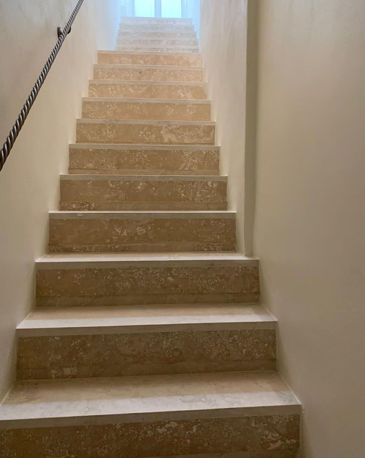 A staircase with a handrail, leading upwards.